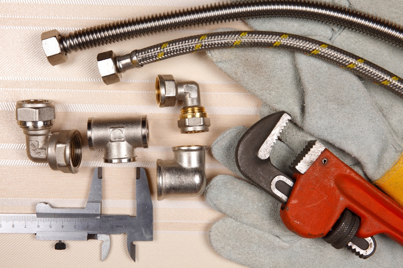Plumber working on pipes in a Swiss Cottage home